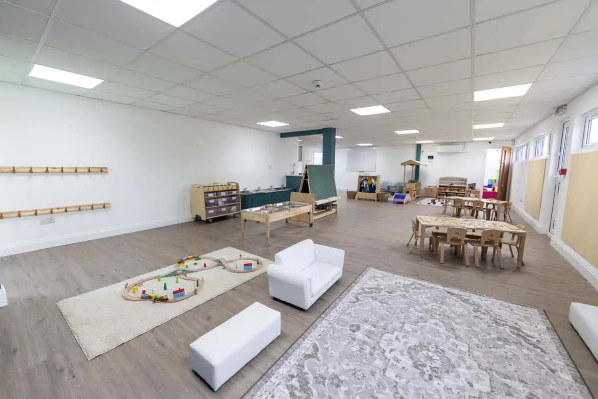 Spacious and bright nursery room with toys, furniture, and play areas at Monkey Puzzle Kingston.