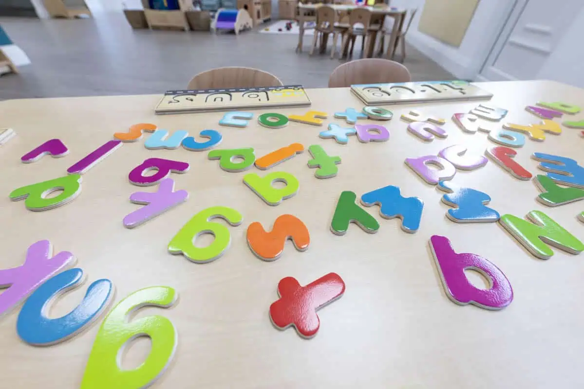 Colorful foam numbers and letters on a nursery table for early learning.