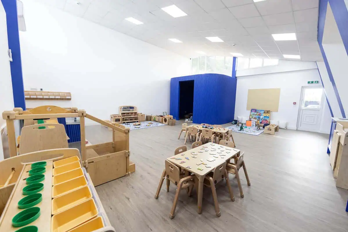Bright, spacious nursery room with wooden furniture and play areas.