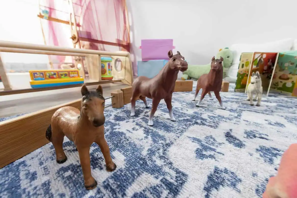 Toy animal figures on a blue patterned carpet at Monkey Puzzle Kingston nursery.