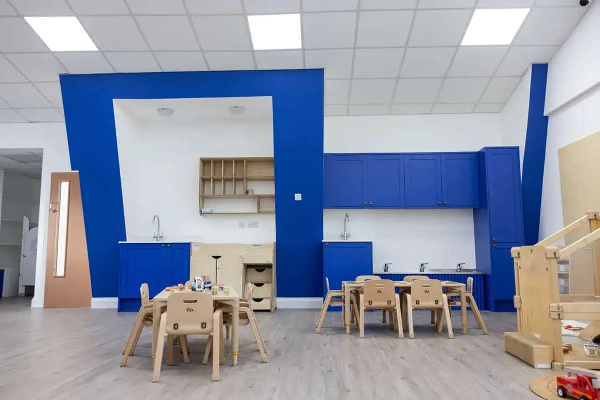Bright and modern nursery room with blue and white decor and wooden furniture.