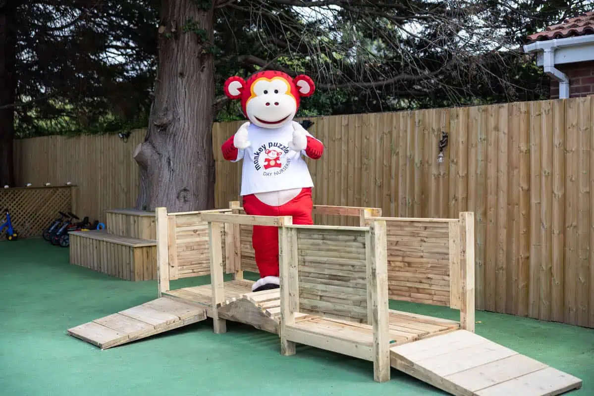 Costumed monkey mascot on wooden playground at Monkey Puzzle Kingston.